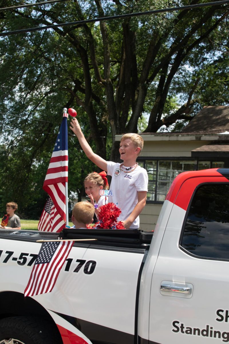 A kid throws a small football into the crowd during the Charleston 4th of July Parade Polk Ave in Charleston, IL on July 4.