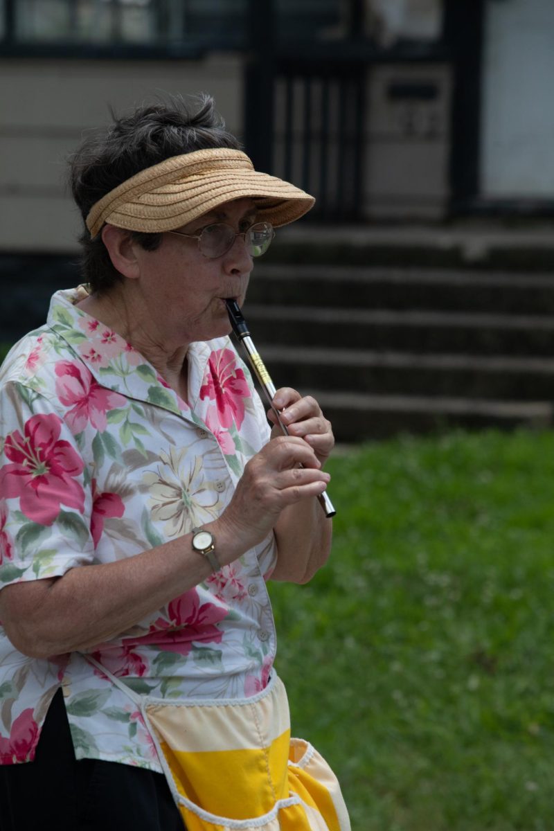 A woman apart of the Coles County Democrats play a tin whistle during the Charleston 4th of July Parade Polk Ave in Charleston, IL on July 4.