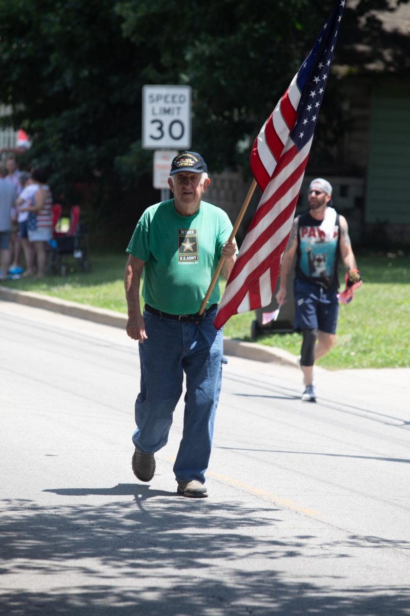 An Army Vietnam Veteran carries the American Flag while walking in the Charleston 4th of July Parade Polk Ave in Charleston, IL on July 4.