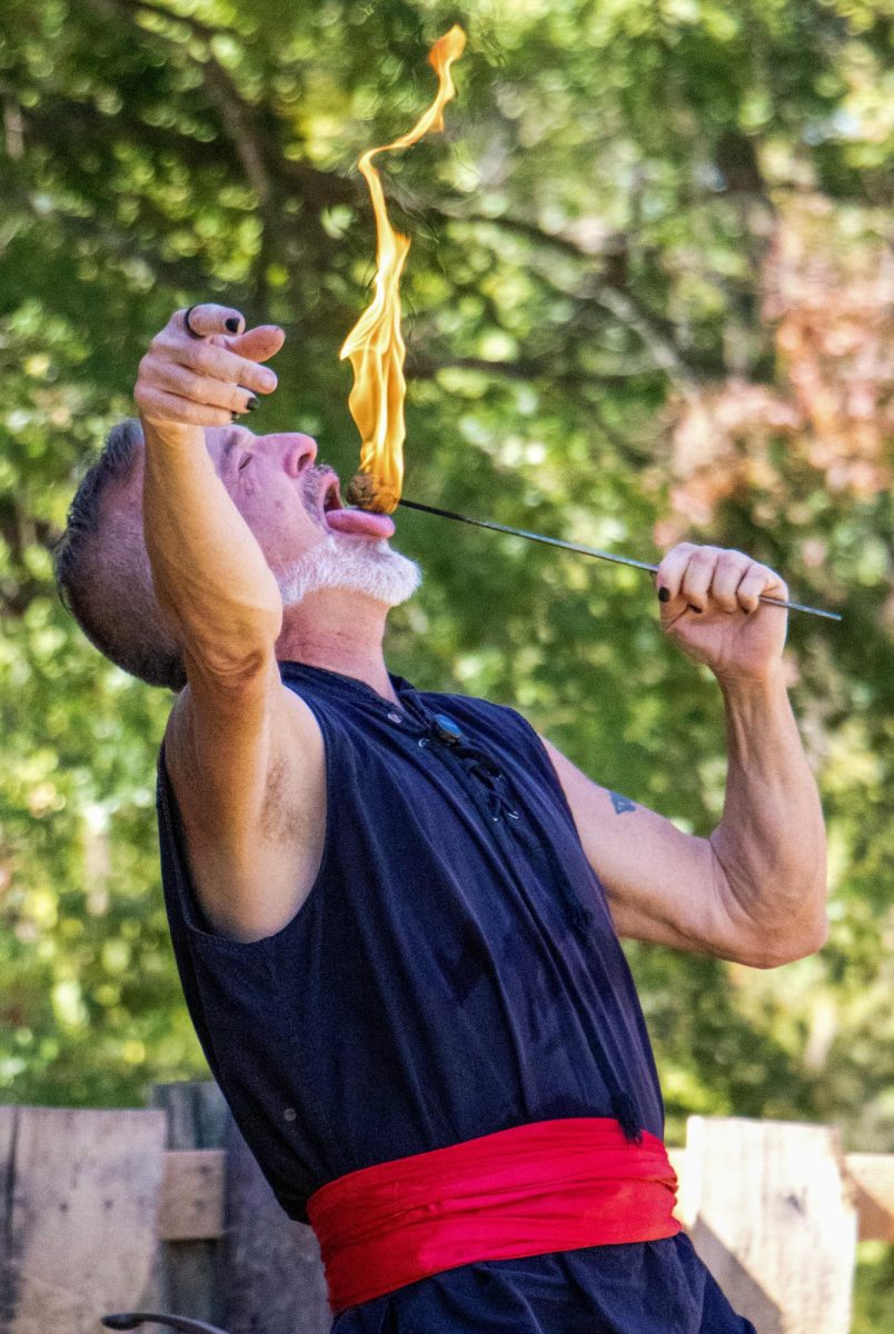 Captain Gwyd (Michael O'Hair) extinguishes a flame with his tongue as part of the Knotty Bits Pirate Circus’ performance at Harvest Frolic on Sept. 28, 2025. O'Hair started the group 21 years ago in Grand Rapids, Michigan. 