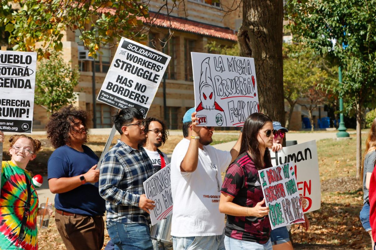 People at the Students for Socialism Anti-ICE protest walk past EIU's Martin Luther King Jr University Union as they protest against ICE on Sunday.