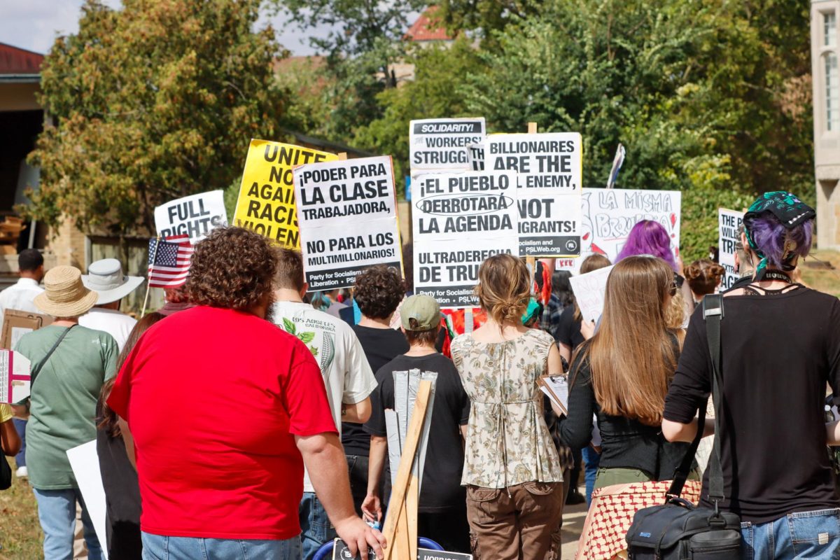 People at the Students for Socialism Anti-ICE protest walk past EIU's Booth Library as they protest against ICE on Sunday.