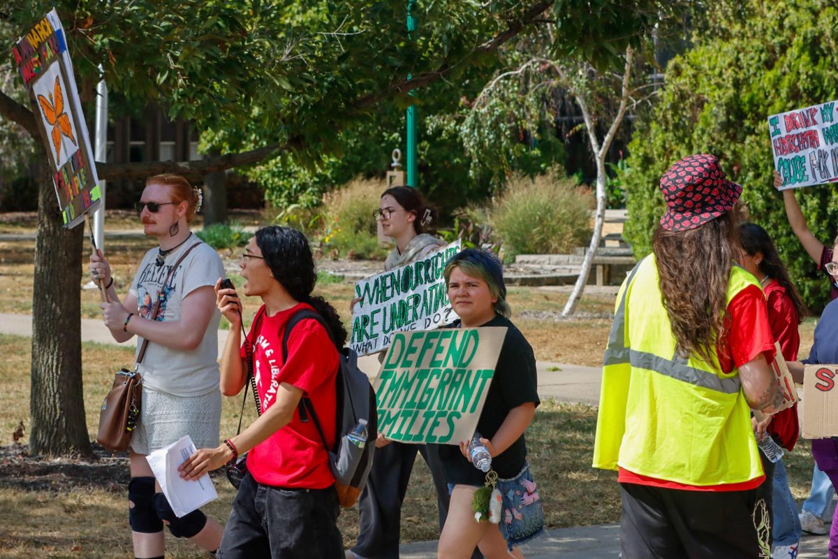 Students for Socialism president Jason Farias (in red) leads a group protesting against ICE in EIU's South Quad apart of the EIU's Students for Socialism Anti-ICE protest on Sunday.