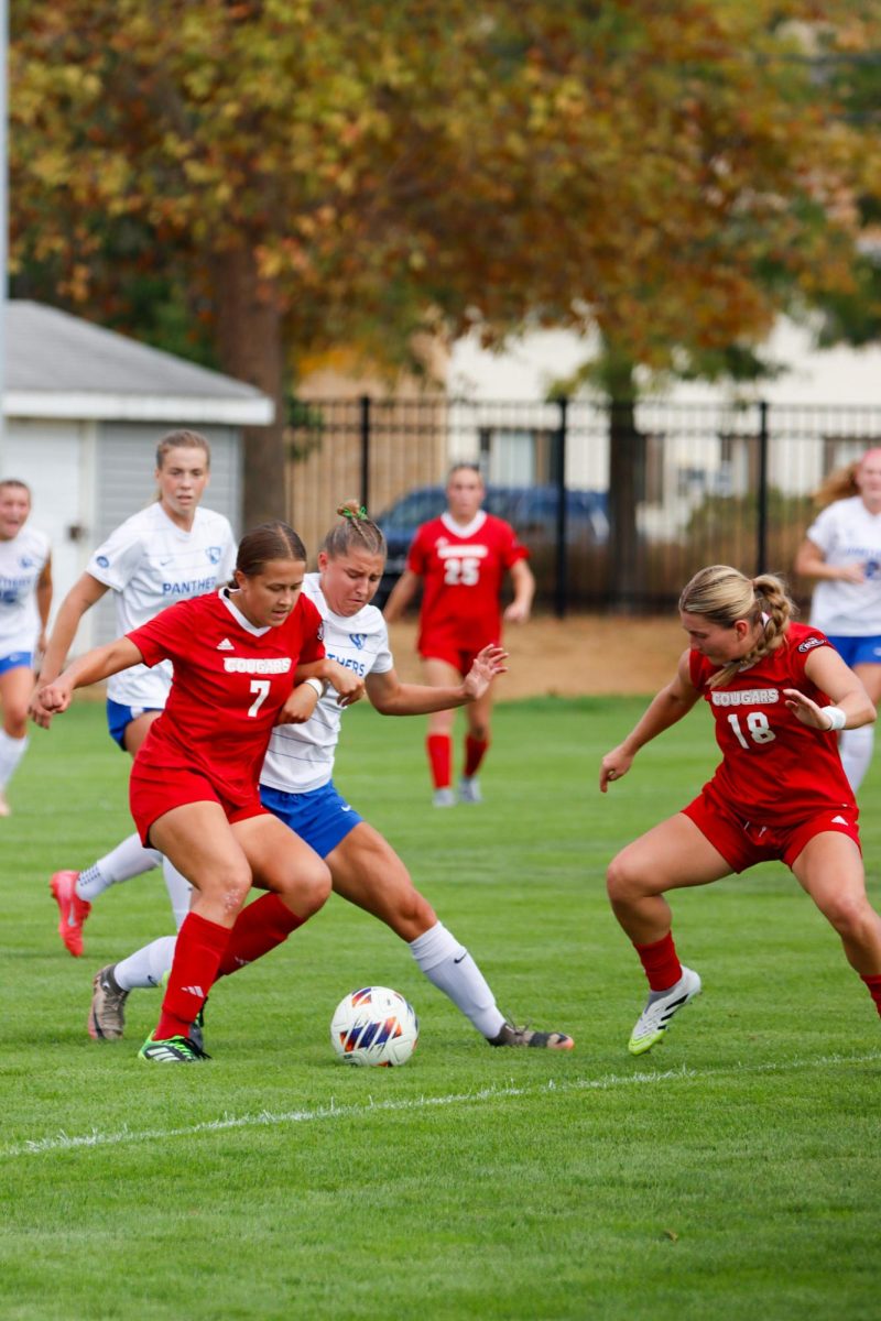 Southern Illinois University Edwardsville freshman middle fielder Claire Nieroda (7) fights for the ball with EIU junior forward Abby Reinl as SIUE senior defenseman Allie Fishering (18) approaches the ball during EIU's 2-0 win over SIUE at Lakeside field on Sunday.