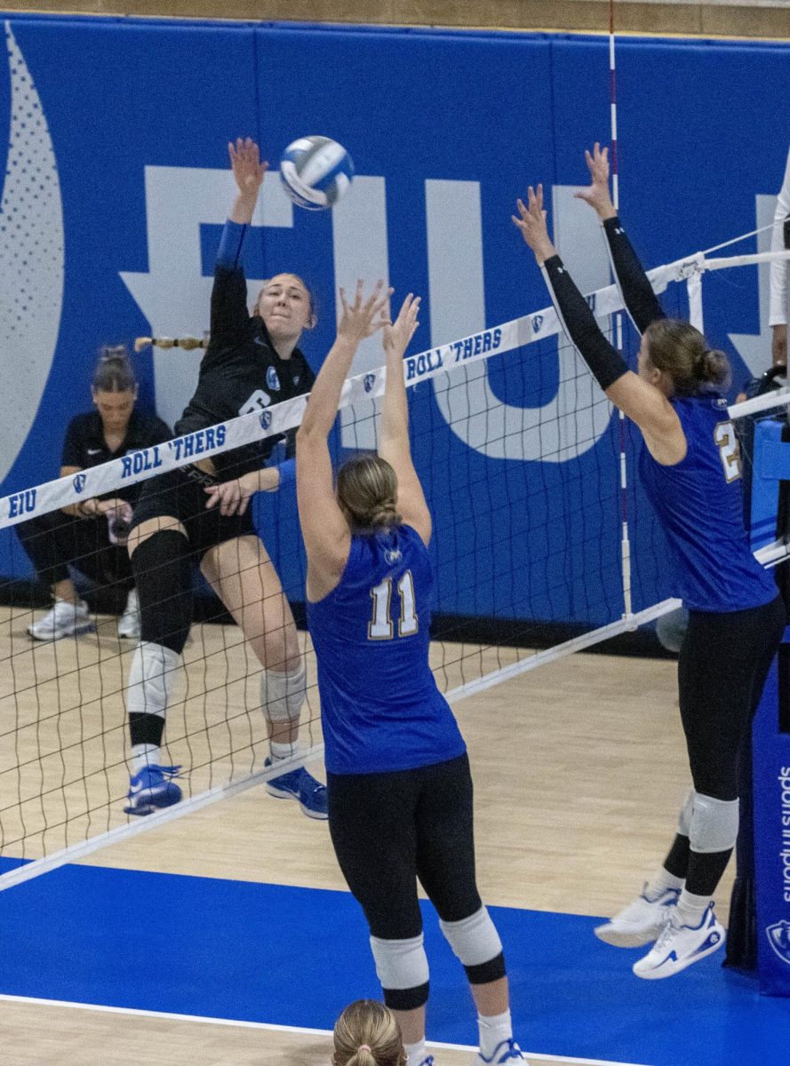 EIU volleyball sophomore outside hitter Katie Kopshever tries to send a shot over Morehead State graduate student middle blocker Bailey Brashear (left) and senior outside hitter Sarah Heath (right) during Eastern’s 3-1 win over Morehead State at the Gardella Family Court in McAfee gym on Friday.