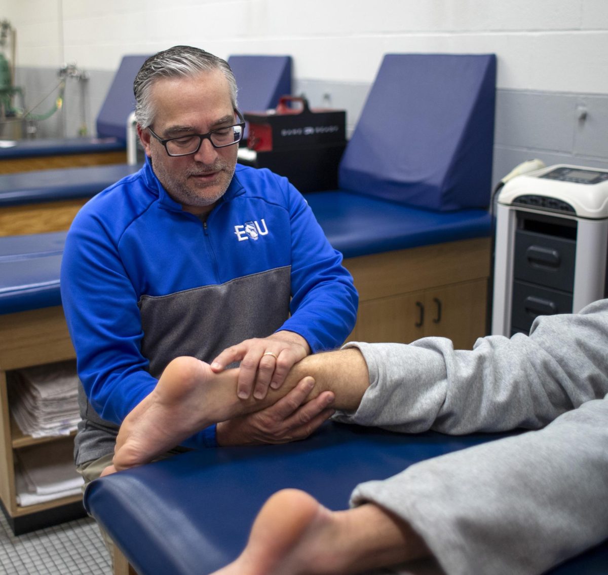 Eastern Illinois University's assistant athletic director, Jim Nave, works on an athlete's achilles in the training room in Groniger Arena on Monday.