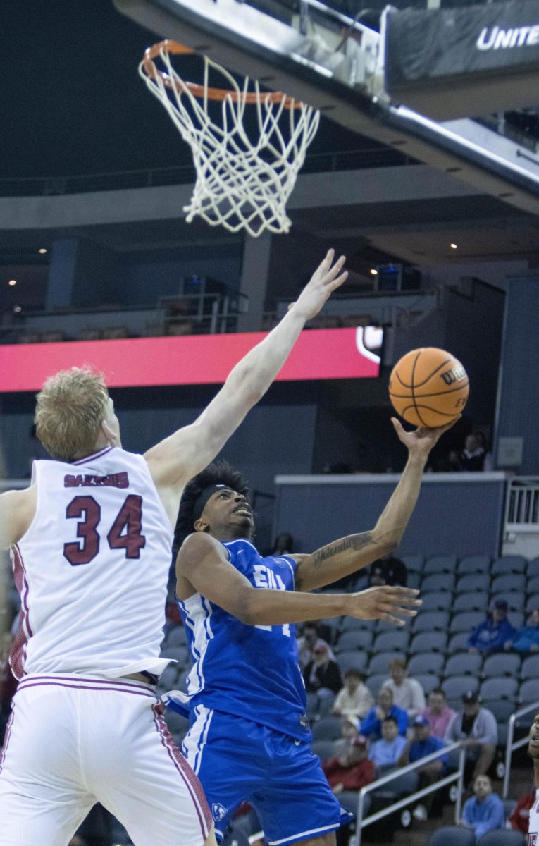 Sophomore forward Terry McMorris takes a left-handed layup over SIUE center Arnas Sakenis during EIU men’s basketball’s 77-71 win over five-seed SIUE in the OVC conference tournament at the Ford Center in Evansville, Indiana, on Wednesday.