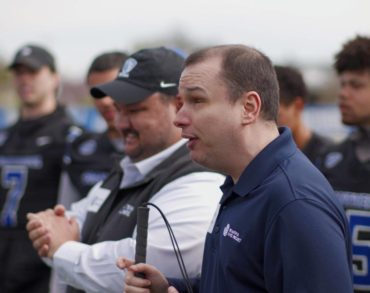 Bryce Weiler, the co-founder of the Beautiful Lives Project, speaks to a group of the project's participants, EIU's football players and coaches on Wednesday at O'Brien Field.