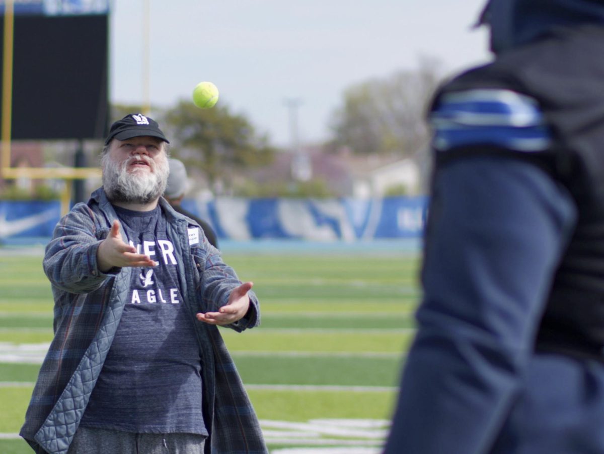Jason Chavance, a participant of the Beautiful Lives Project, tosses a tennis ball to EIU redshirt sophomore offensive lineman Rahfeeq Katumbusi on Wednesday at O'Brien Field.