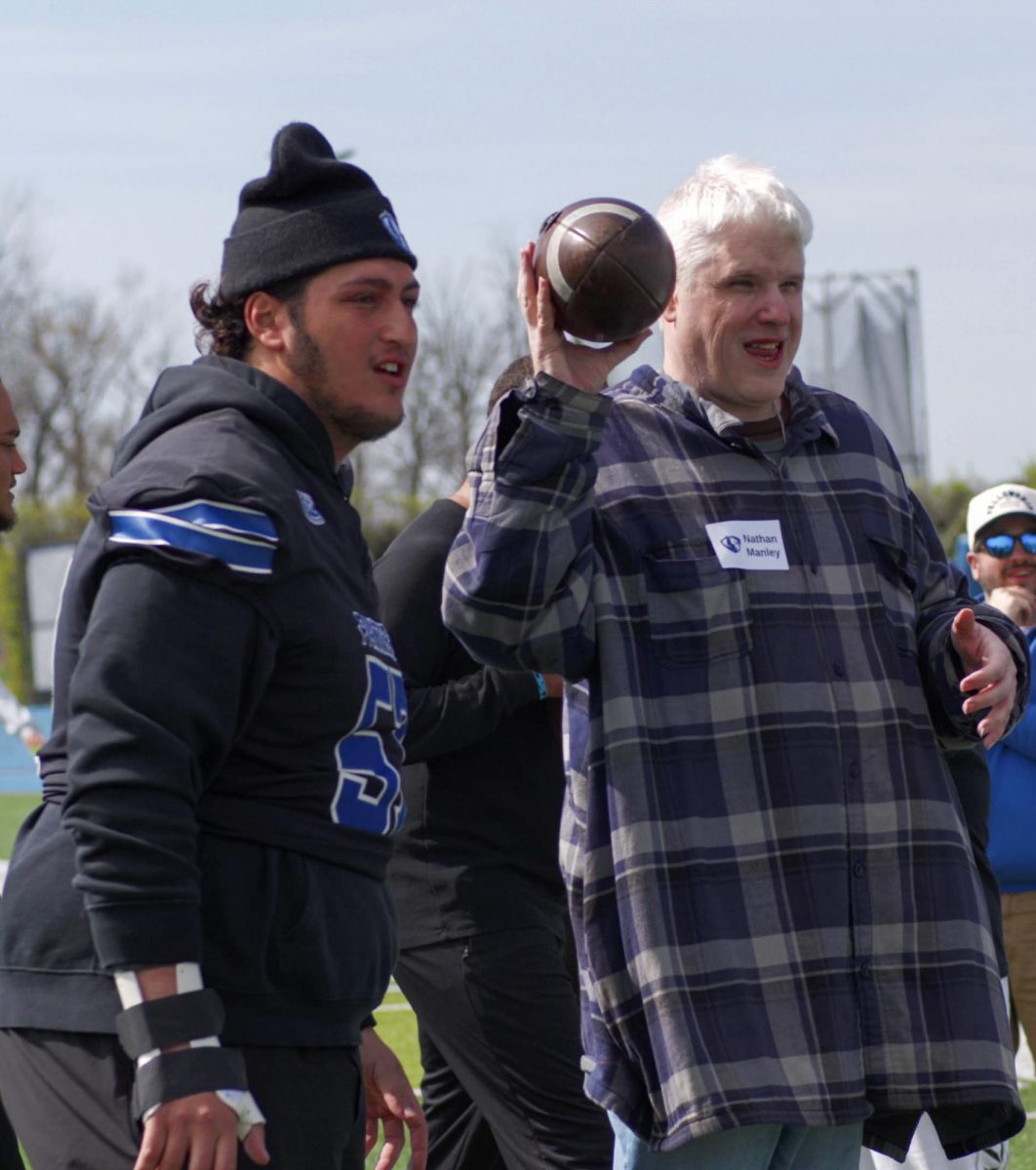 EIU redshirt junior offensive lineman Panayiotis Mihalopoulos coaches Nathan Manley, a participant of the Beautiful Lives Project, on how to throw a football on Wednesday at O'Brien Field.