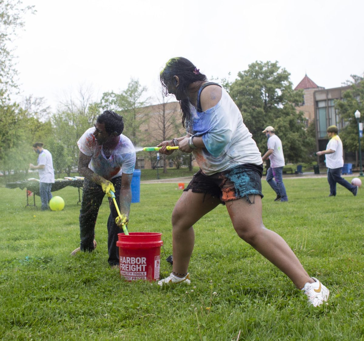 Krishna Daravath (right) gets sprayed with water by Vani Patel (left) at Holi Color Fest on Friday on the Library Quad. EIU Association of International Students (AIS) and Indian Student Association (ISA) hosted Holi Color Fest. The organizations had several white t-shirts for attendees to use, which brightly showed the colors. There were also water toys available for attendees to spray each other with.