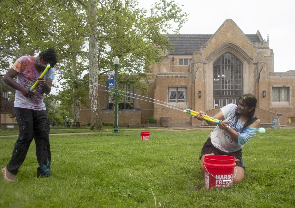 Krishna Daravath (left) gets sprayed with water by Vani Patel (right) at Holi Color Fest on Friday on the Library Quad. EIU Association of International Students (AIS) and Indian Student Association (ISA) hosted Holi Color Fest. The organizations had several white t-shirts for attendees to use, which brightly showed the colors. There were also water toys available for attendees to spray each other with.