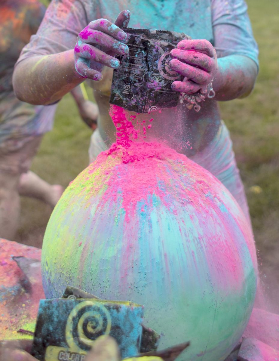 Jamaya Fuller pours pigment onto a ball at Holi Color Fest on Friday on the Library Quad. Fuller is vice-president of Couture Models and she attended Holi Color Fest with her friends in the organization.