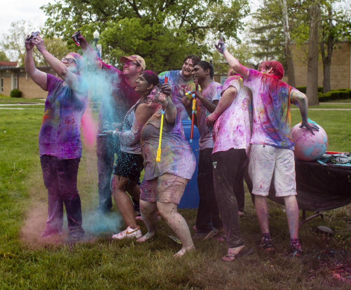 Holi Color Fest attendees take a selfie with Heather Crank, assistant director of study abroad and her husband, Jimmy Crank on Friday on the Library Quad. Holi Color Fest used to be hosted by the EIU study abroad program, before the EIU Association of International Students (AIS) and Indian Student Association (ISA) began hosting the event.