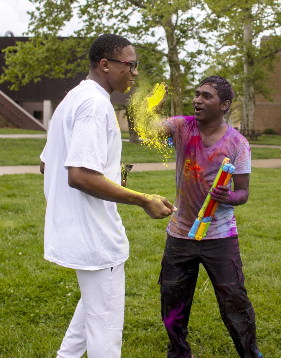 Technology major Krishna Daravath (right) pours pigment onto Art education major Josiah Nesbitt (left) at Holi Color Fest on Friday on the Library Quad. Nesbitt attended Holi Color Fest with his friends in Couture Models.