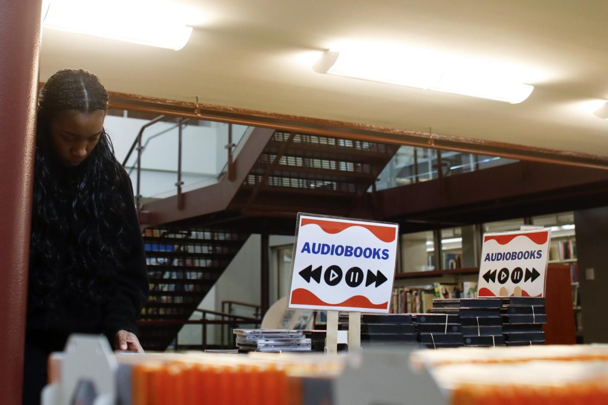Finance major Reanna Cannon looks through the audiobook section at the Media Mayhem event at Booth Library on Wednesday afternoon.