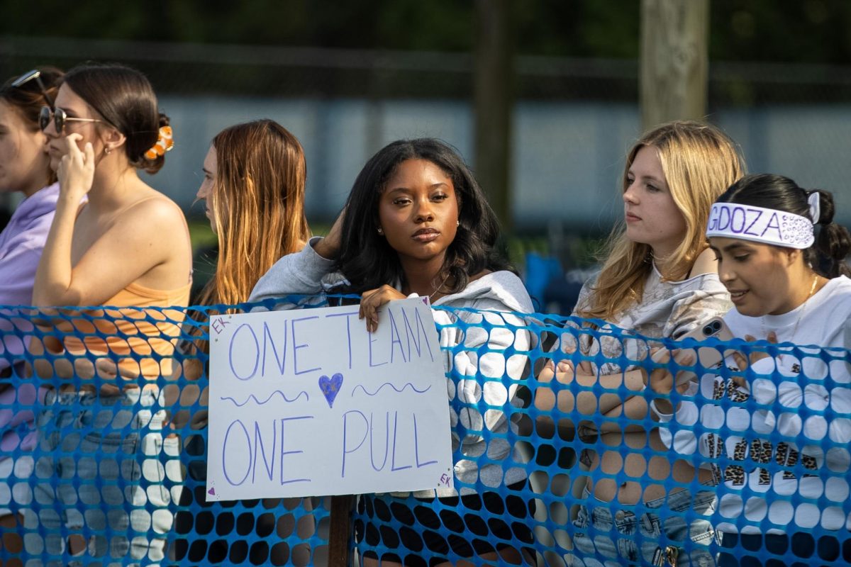 Sigma Kappa member, Mia Griffin holds a sign that reads “One Team, One Pull” at the Tugs event during Greek Week across  the campus pond on Wednesday afternoon.  Sigma Kappa was paired up with Sigma Phi during Greek Week and the pairing received first overall.