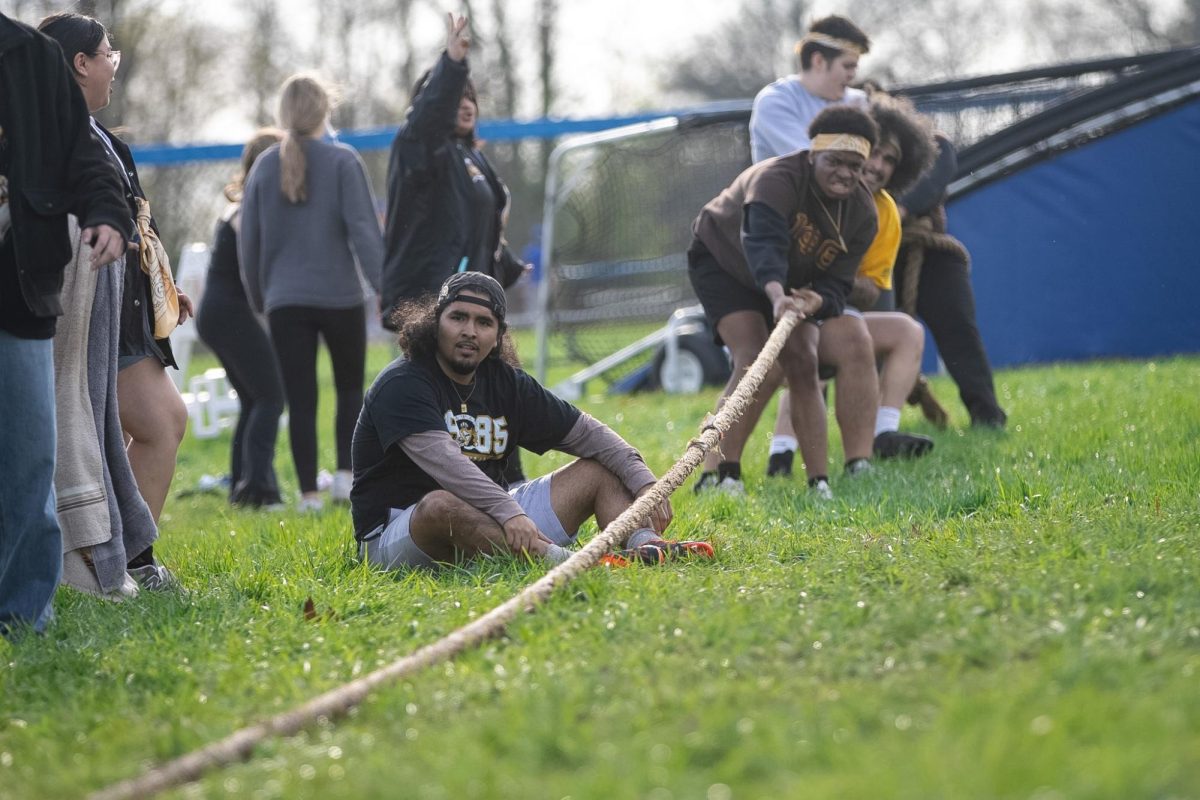 Alpha Psi Lambda member Marco Herrera sits and rests while his team pulls on their side of the rope during their match at the Tugs event during Greek Week across the campus pond on Wednesday afternoon. Alpha Psi Lambda was paired up with Iota Phi Theta during Greek Week.