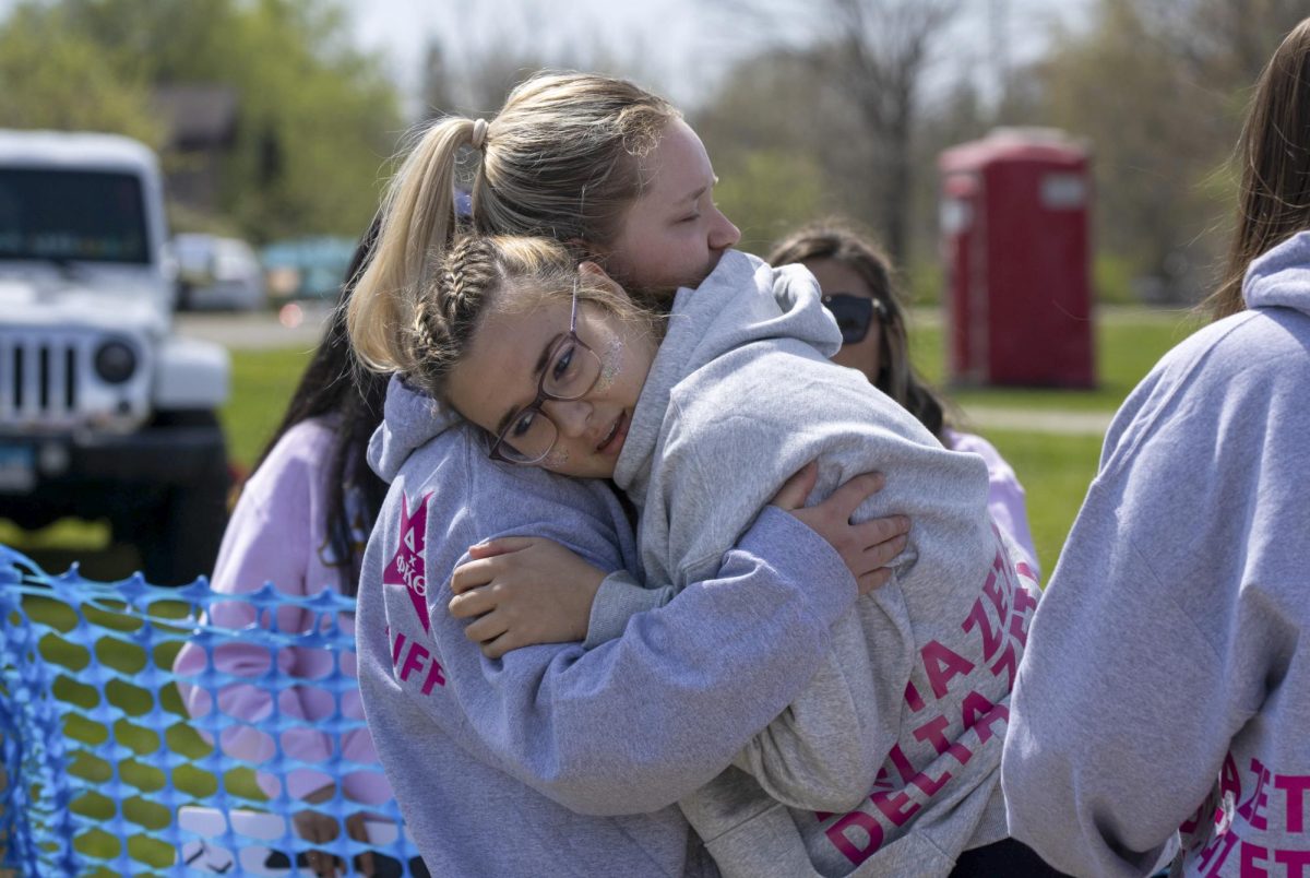 Delta Zeta members Brayden Duff (left) and Callie Buettner (right) comfort each other after a loss against Alpha Sigma Alpha on Saturday across the campus pond.