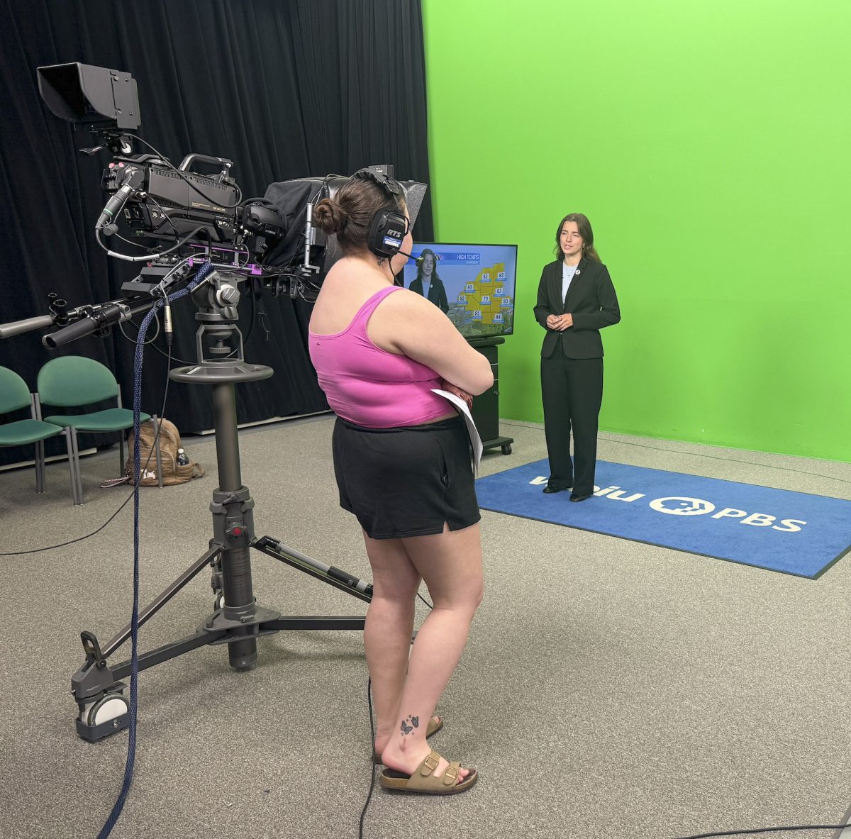 Junior geography major, Emily Davis practices the weather report for WEIU's newswatch while senior human services major Mackenzie Pack works the camera on Thursday in the WEIU studio.