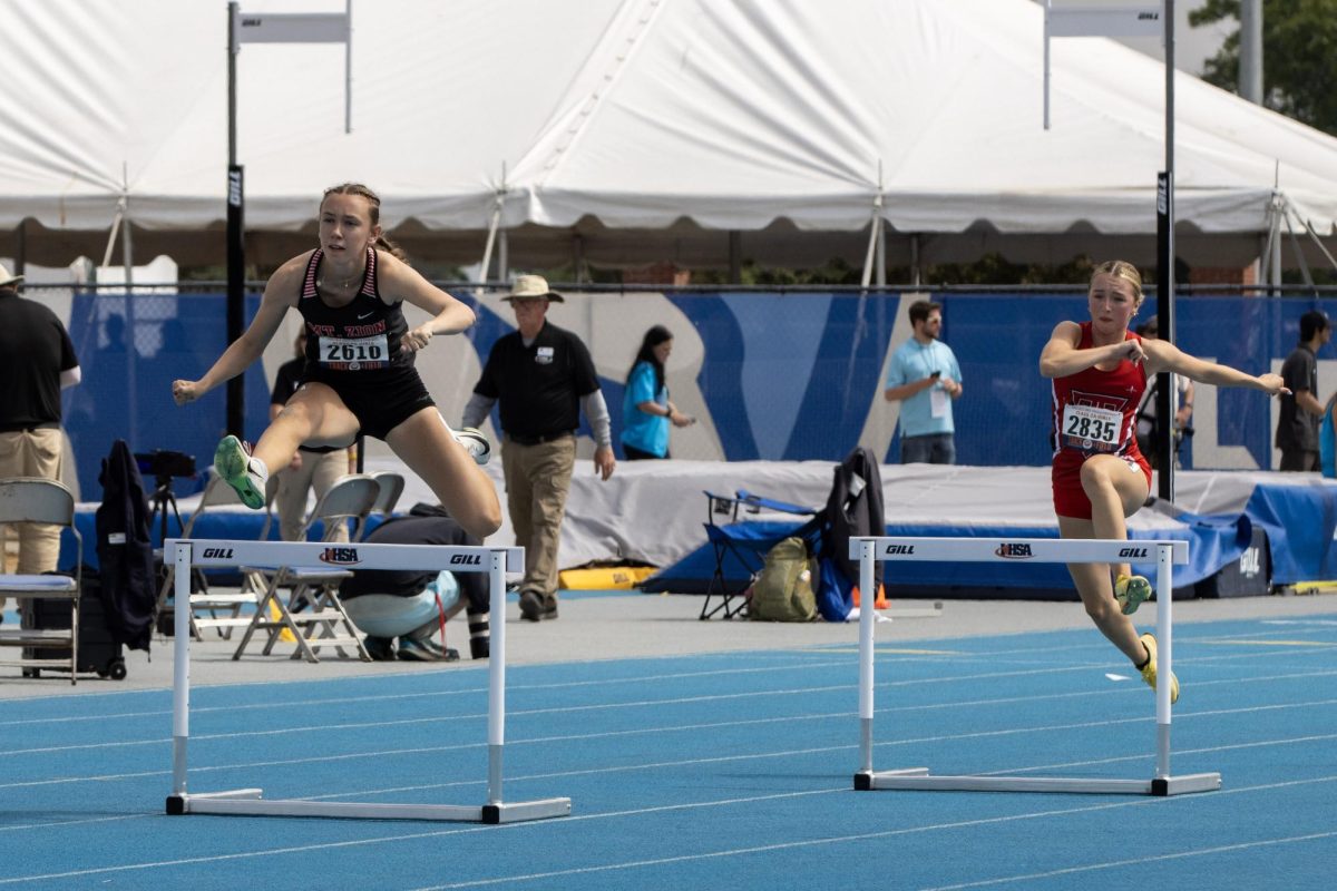 Mt. Zion junior Kendall Smith (left) and Triad junior Ava Gallia (right) jump their hurdles during the Class 2A 300-meter hurdle race at the IHSA girls' state track and field meet at O'Brien Field on Eastern Illinois University's campus in Charleston on Saturday.