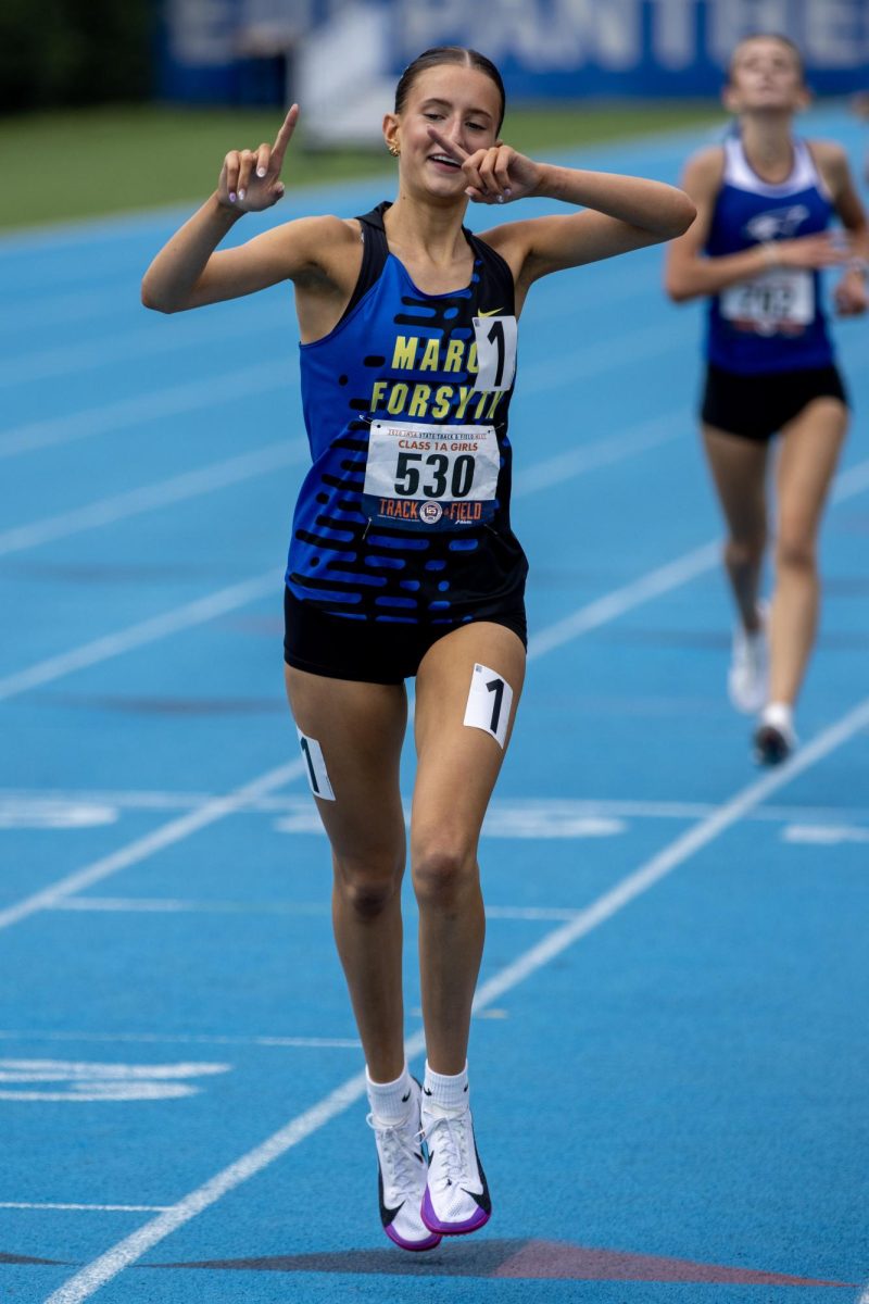 Maroa-Forsyth senior Klaire Eighner throws up her fingers after finishing in first place in the Class 1A 1600-meter race at the IHSA Girls' state track and field meet at O'Brien Field on Eastern Illinois University's campus in Charleston on Saturday.