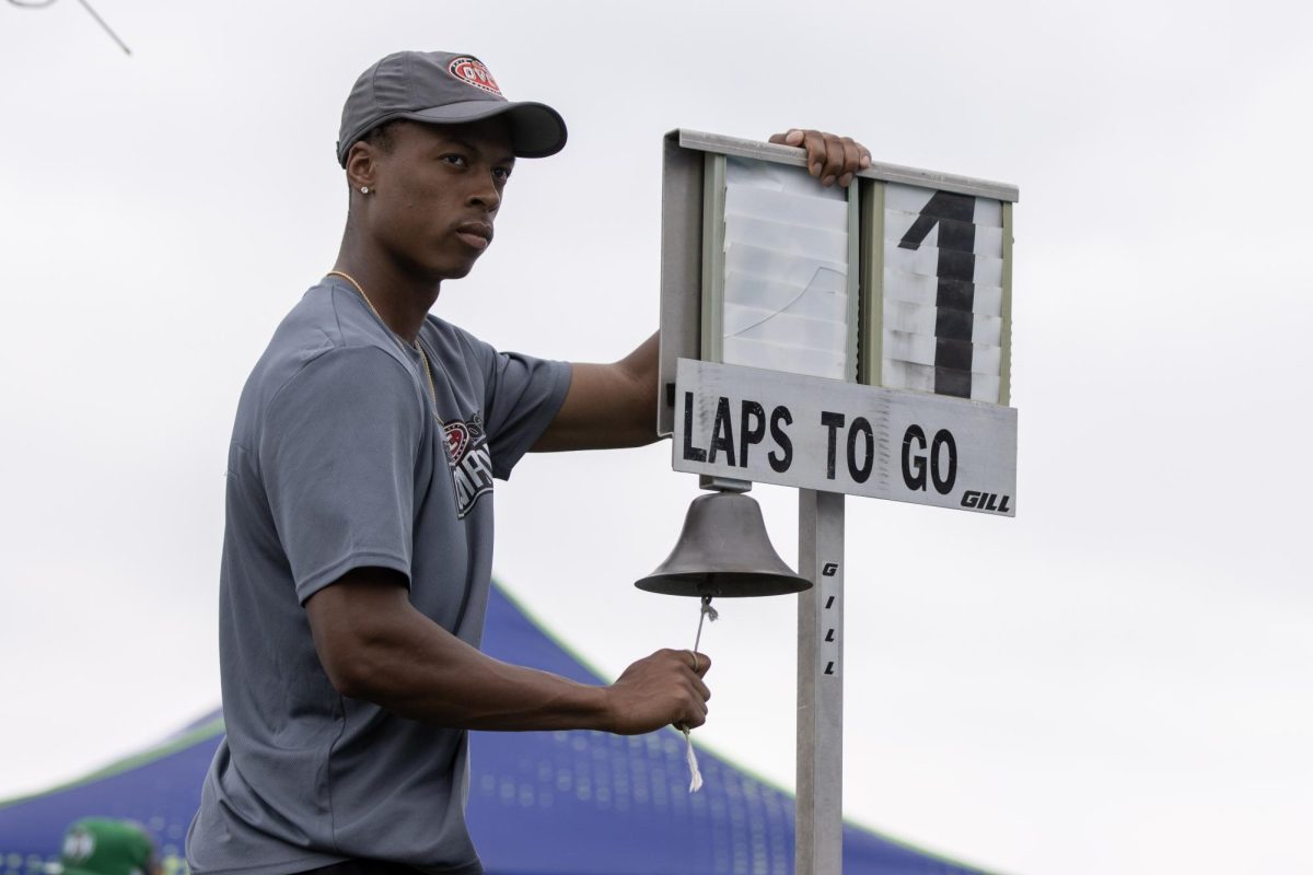 Eastern Illinois University fifth year track runner Shawn Lacy rings the bell to signal one lap remaining in the Class 3A 1600-meter race at the IHSA girls' state track meet at O'Brien Field on Eastern Illinois University's campus in Charleston on Saturday.