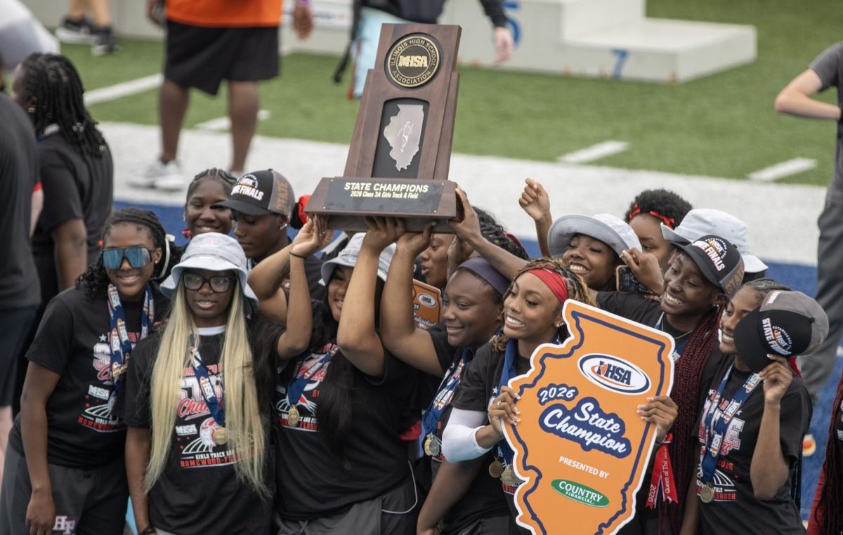 The Homewood-Flossmoor girls team holds up their trophy after tying for first place for the Class 3A championship. Homewood-Flossmoor also broke the all-time state Class 3A 4x200 record with a time of 1:36.85.
