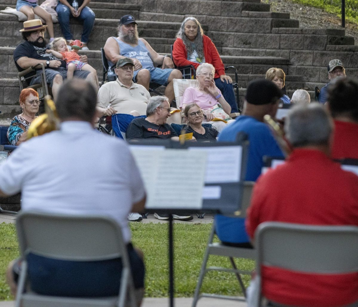 Members in the audience for the Charleston Community Band talk to each other as they watch the first of its weekly summer performances at Kiwanis Park on Thursday.