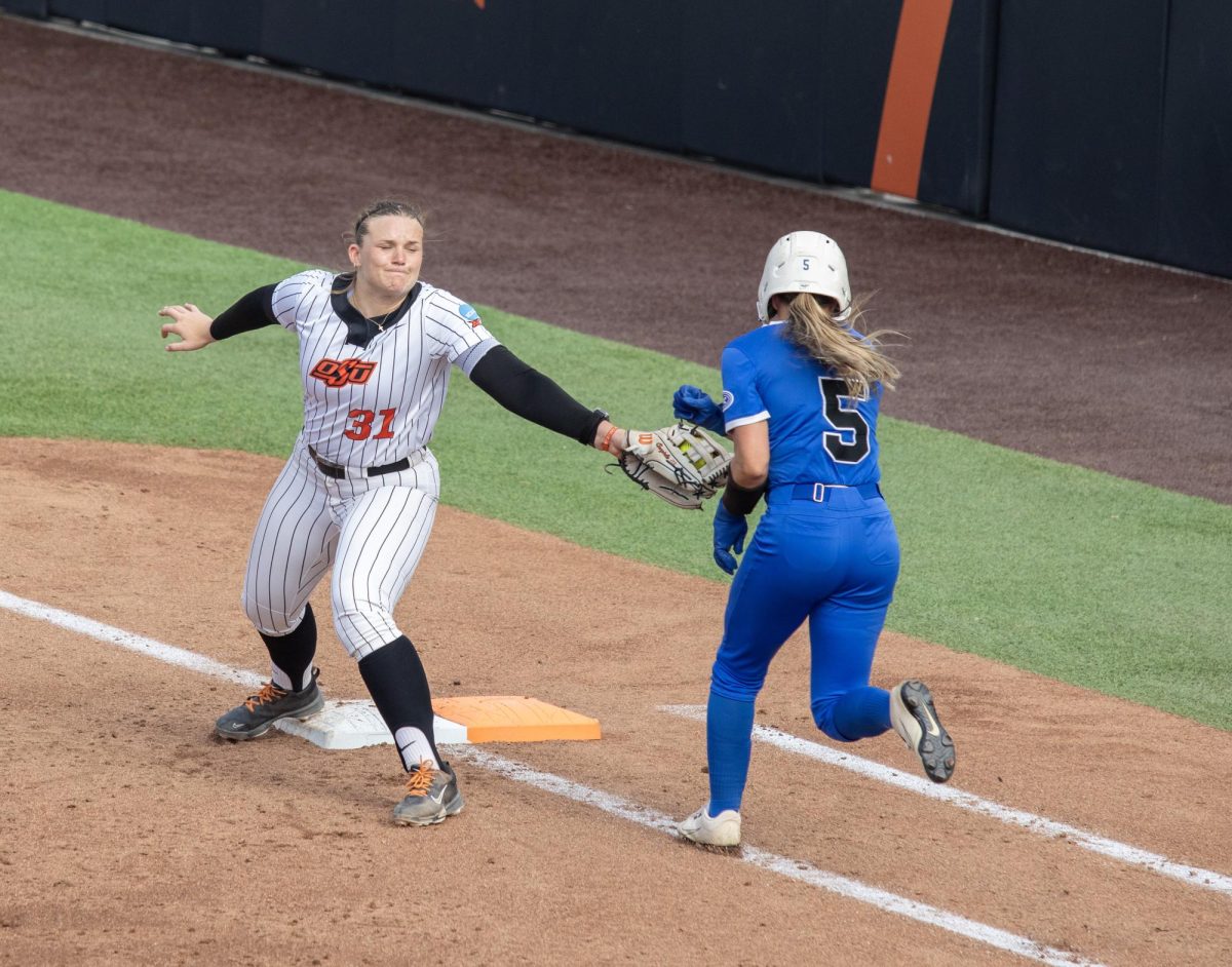 Oklahoma State University softball senior outfielder Lexi McDonald (left) steps on first base for the out as Eastern Illinois University senior outfielder Marybeth Dyson (right) runs to the bag during EIU’s 16-0 loss to Oklahoma State University in the second game of the NCAA Stillwater Regional on Friday.