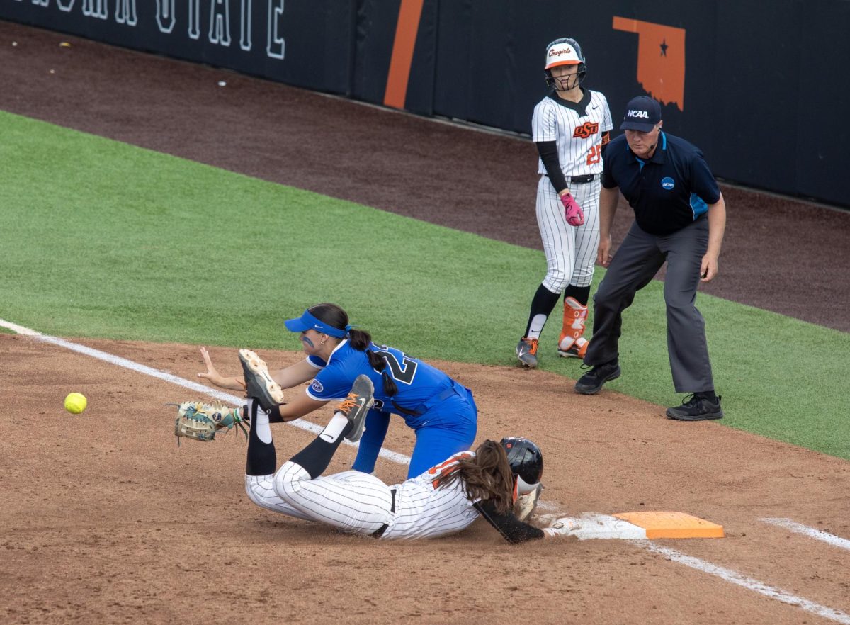Eastern Illinois University softball sophomore first baseman Abbi Hatton (back) waits for a ball while trying to get junior infielder Karli Godwin out at first base during EIU’s 16-0 loss to Oklahoma State University in the second game of the NCAA Stillwater Regional on Friday.