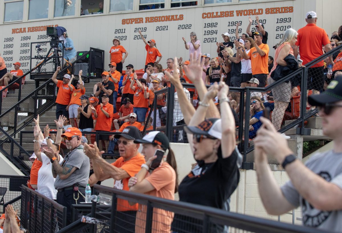 Oklahoma State University softball fans celebrate in the stands after a home run during EIU’s 16-0 loss to Oklahoma State University in the second game of the NCAA Stillwater Regional on Friday.