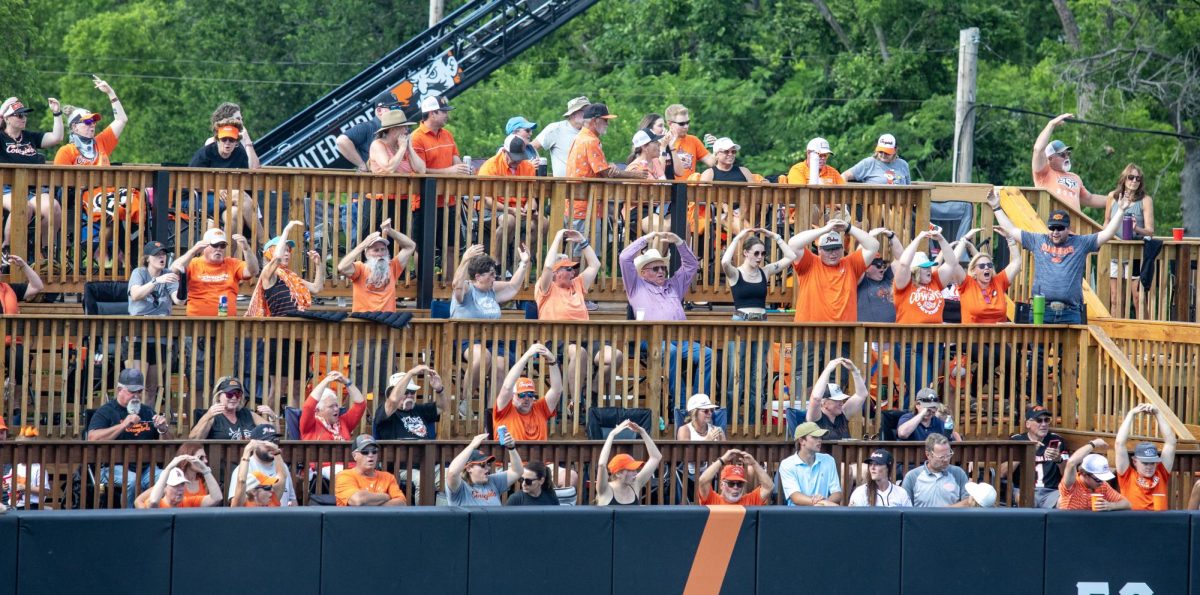 Oklahoma State University softball fans make OSU with their arms in the outfield after a home run during EIU’s 16-0 loss to Oklahoma State University in the second game of the NCAA Stillwater Regional on Friday.