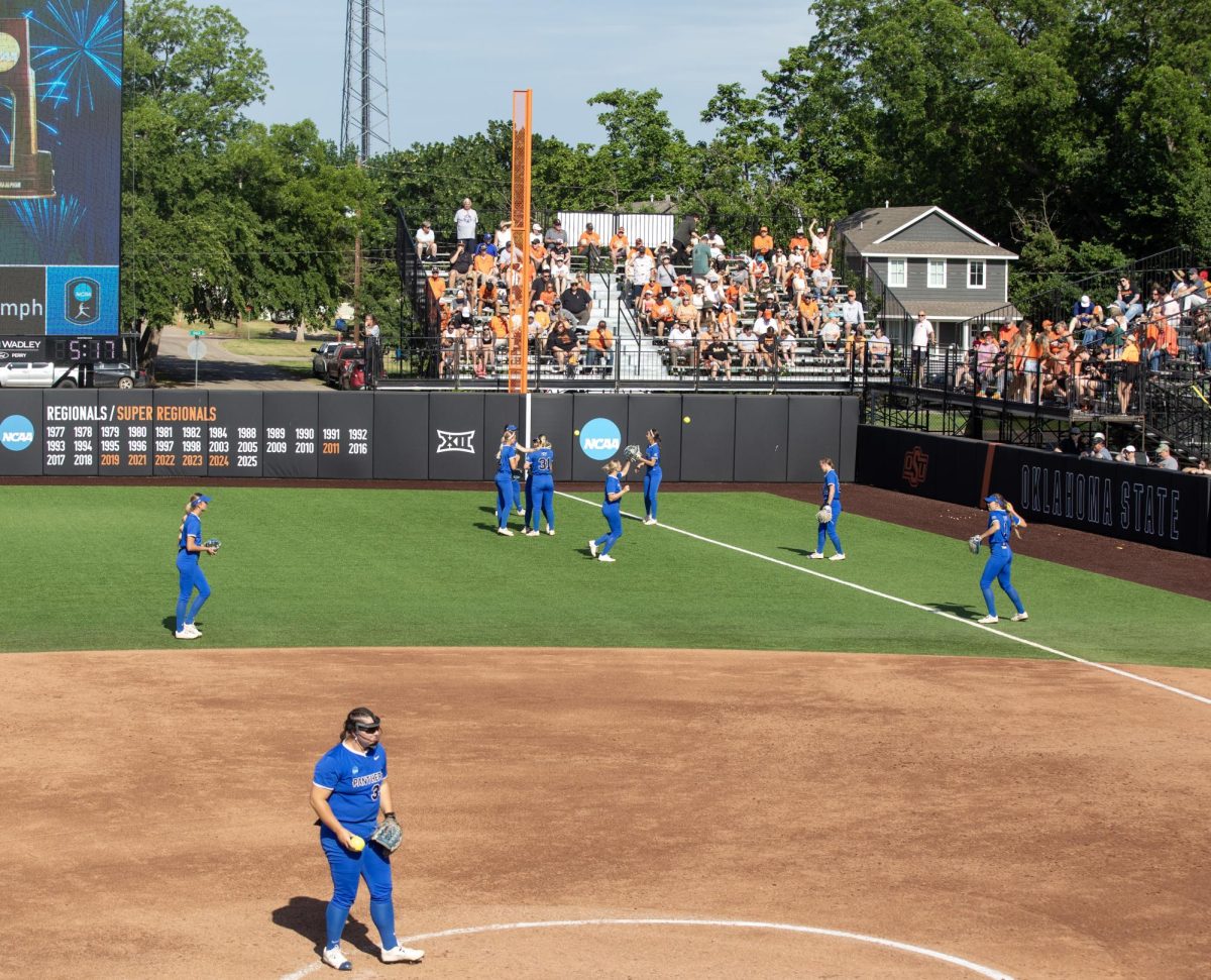 The Eastern Illinois University softball team warms up before an inning starts during EIU’s 16-0 loss to Oklahoma State University in the second game of the NCAA Stillwater Regional on Friday.