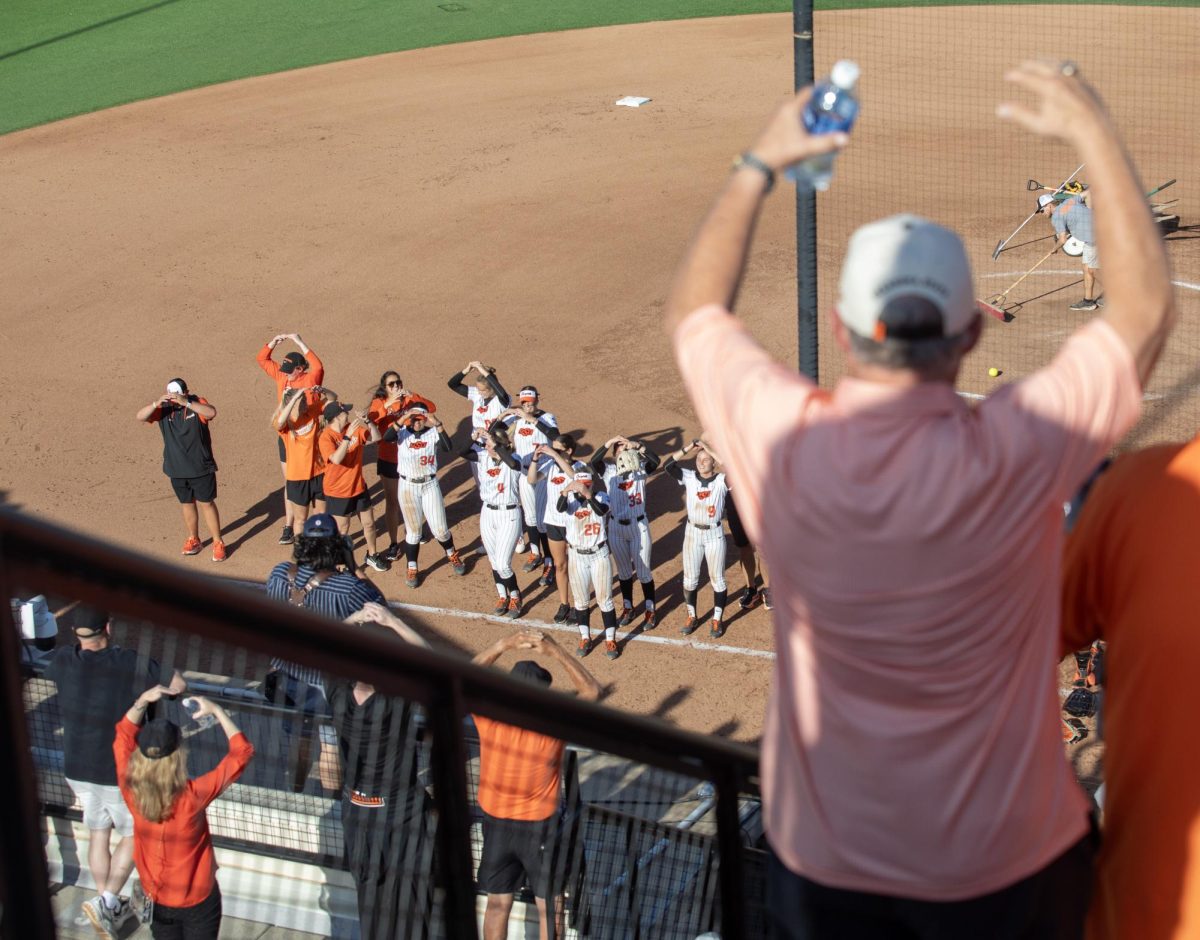 The Oklahoma State University softball team makes OSU with their hands as the fans do the same thing after EIU’s 16-0 loss to Oklahoma State University in the second game of the NCAA Stillwater Regional on Friday.