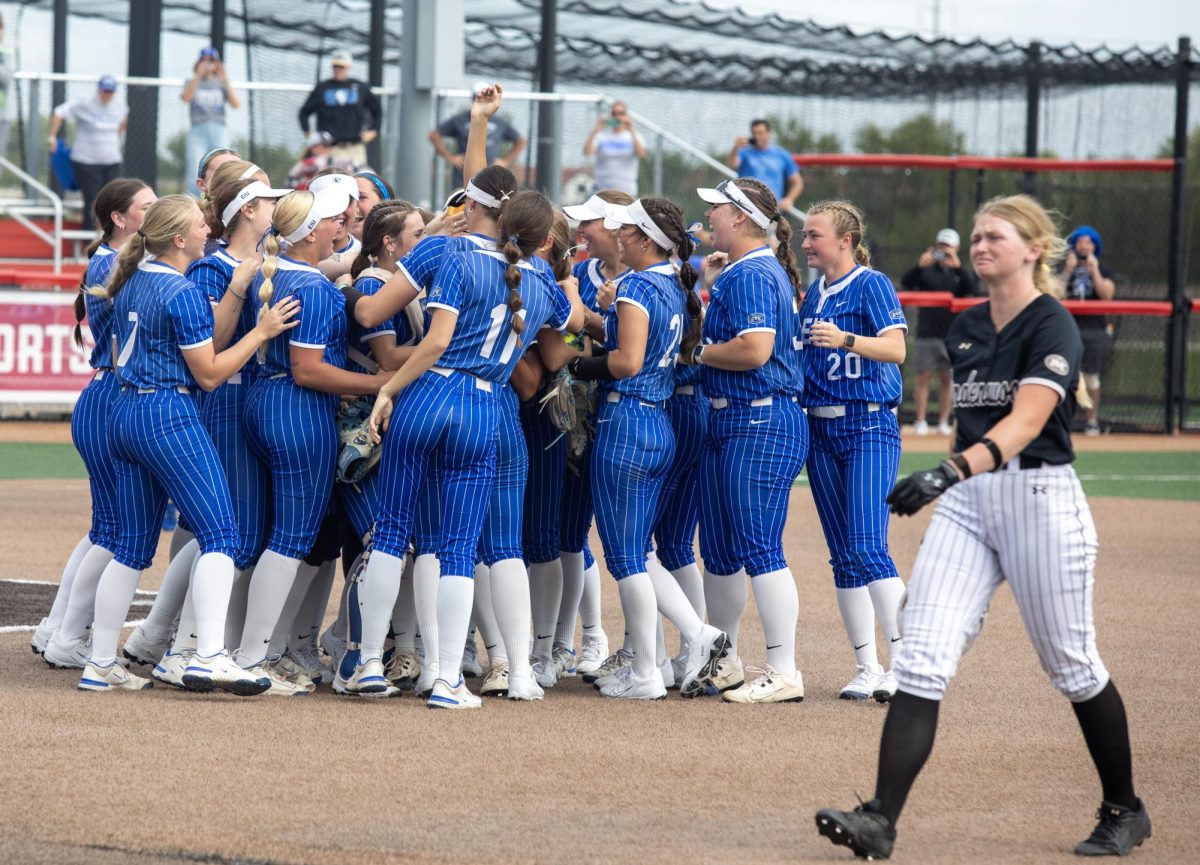 The Eastern Illinois University softball team celebrates while Lindenwood walks off the field in tears after EIU wins the OVC championship at OSF Healthcare Field at the Louisville Sports Sluggers Complex on Saturday.
