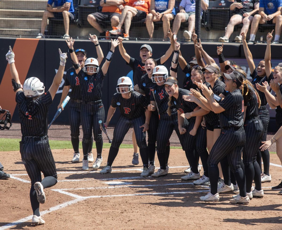 The Princeton University softball team celebrates as junior infielder Sonia Zhang runs to home plate after her home run during Eastern Illinois University’s 2-1 loss to Princeton at Cowgirl Stadium on Saturday.