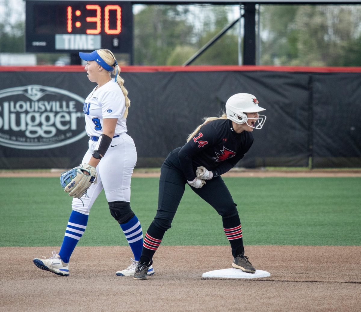 Eastern Illinois University softball freshman infielder Viola Smith (left) walks away after Southeast Missouri State senior outfielder Brittany Affolter (right) gets on base and celebrates during EIU’s 7-6 win against Southeast Missouri State in the first round of the Ohio Valley Conference tournament at OSF Healthcare Field at the Louisville Sports Sluggers Complex on Thursday.