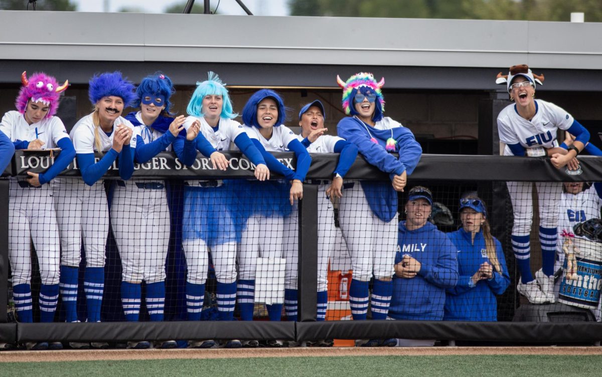 The Eastern Illinois University softball team cheers in the dugout while wearing fun outfits during EIU’s 7-6 win against Southeast Missouri State in the first round of the Ohio Valley Conference tournament at OSF Healthcare Field at the Louisville Sports Sluggers Complex on Thursday.