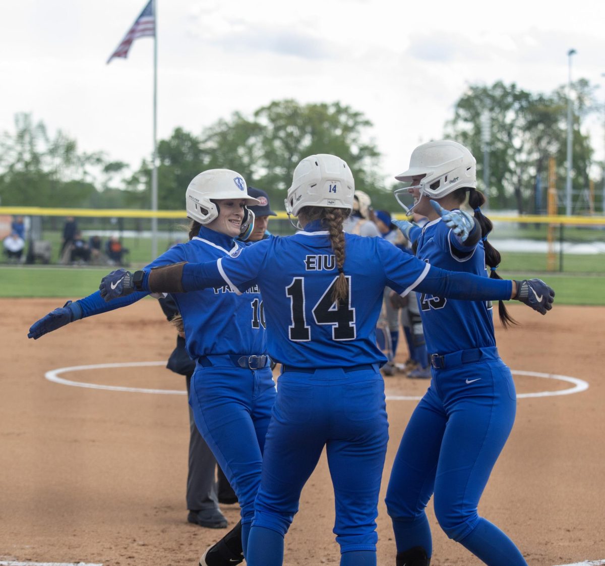 Eastern Illinois University softball junior catcher Sophia Olman (left) goes for a hug with senior infielder Lizzie Stiverson (center) and sophomore utility player Abbi Hatton (right) after Olman’s home run during EIU’s 9-4 win over Tennessee State University at Williams Field on Friday.