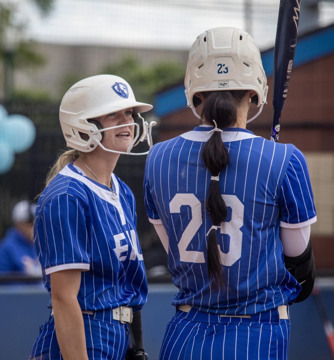 Eastern Illinois University softball junior outfielder Alisha Frederick (left) talks with sophomore utility player Abbi Hatton (right) after Frederick scores during EIU’s 15-0 win over Tennessee State University at Williams field on Saturday.