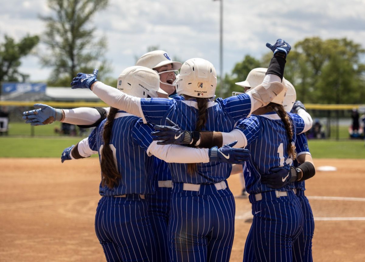 Eastern Illinois University softball sophomore utility player Abbi Hatton hugs with her teammates after her grand slam during EIU’s 15-0 win over Tennessee State University at Williams field on Saturday.