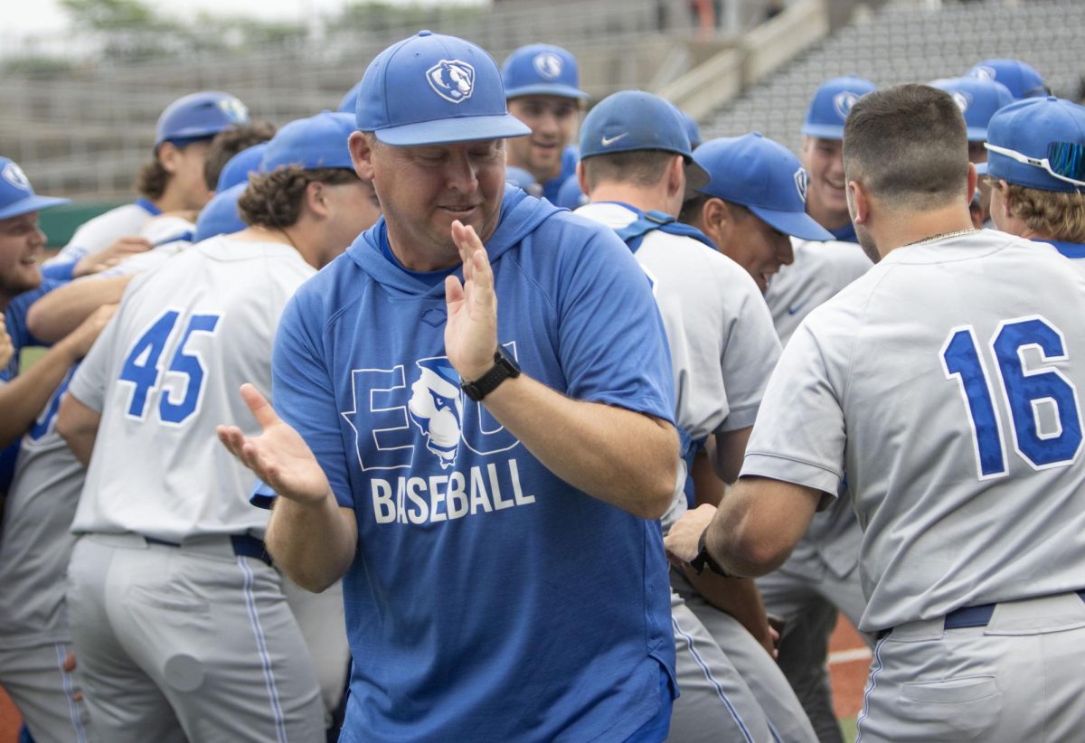 Eastern Illinois University baseball head coach Jason Anderson smiles and claps as his team celebrates after Eastern’s 3-2 win over Southern Illinois Edwardsville in the Ohio Valley Conference tournament.